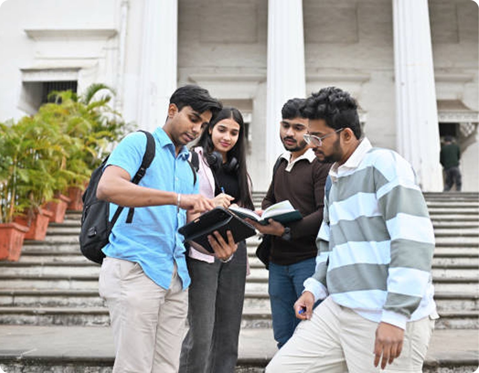 Students reviewing study materials on campus steps