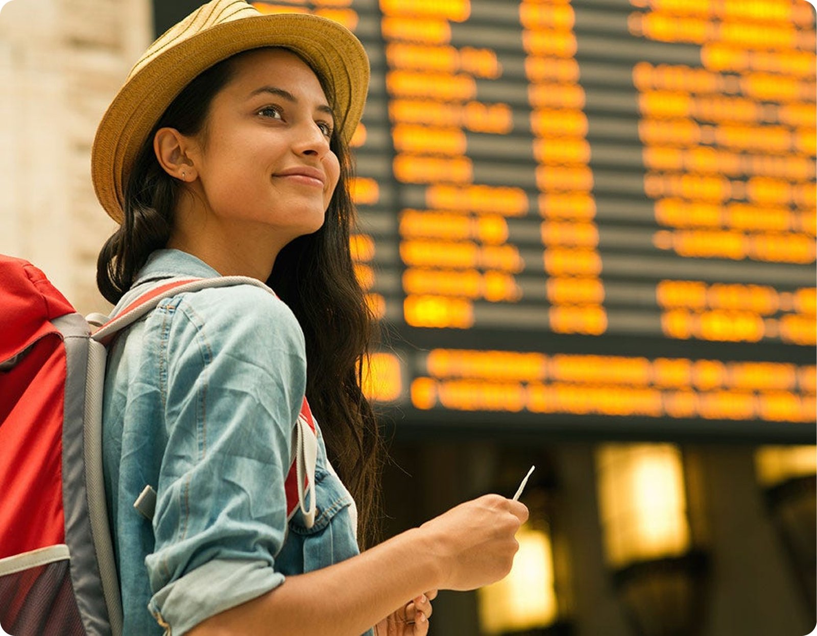 Smiling tourist at an airport departures board